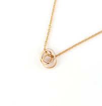 CARTIER - an 18ct three colour gold triple ring suspended from an 18ct yellow gold chain necklace,