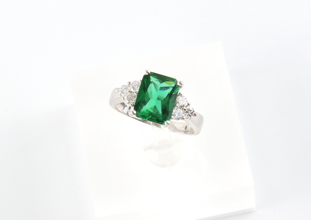 A 14ct white gold green stone (not emerald) & diamond ring, the estimated total diamond weight 0.