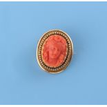 A Victorian unmarked high carat yellow gold carved coral oval brooch, the oval coral cameo depicting