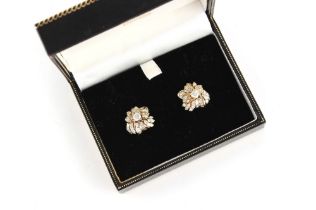 A pair of unmarked yellow gold diamond floral cluster earrings, set with baguette & round