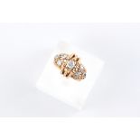 A modern unmarked rose gold (tests 14ct) diamond ring, the round brilliant cut diamonds weighing a
