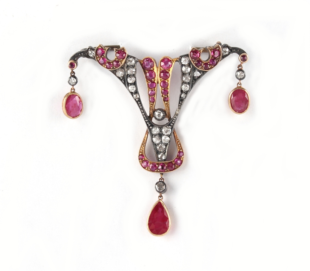 A Belle Epoque style ruby & diamond brooch, set with a pear shaped ruby, two oval cushion cut rubies