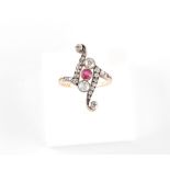 A late 19th / early 20th century ruby & diamond scroll form ring, with a round cut ruby & old cut