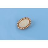 An unmarked high carat yellow gold opal & seed pearl oval brooch, 25mm long.