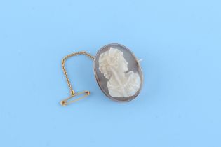 A carved hardstone cameo brooch depicting a maiden, 33 by 25mm (excluding pin), with safety chain,