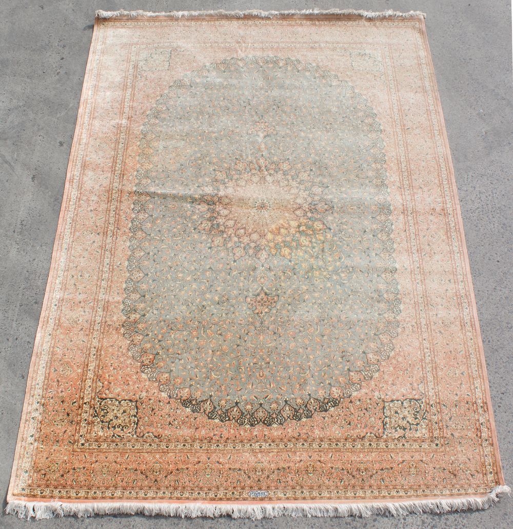 Property of a lady - a fine Persian Qum silk carpet, with pale pink ground, signed to one end in