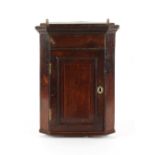 Property of a lady - a small George III oak corner wall cabinet, with fielded panelled door, 23.