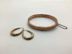 A 9ct Gold Hinged Bangle, leaf engraved to the front, hinged to snap clasp, Birmingham 1900 (overall