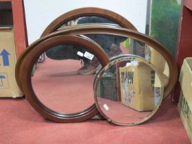 Three circular mirrors two with mahogany frames the other with stand and bevelled edge together with