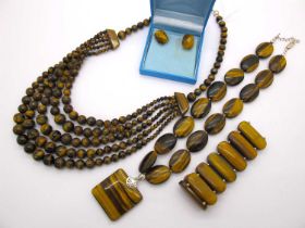 A Modern Tiger's Eye Polished Flat Bead Necklace, together with a multi strand graduated bead