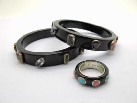 A Pair of Modern Multi Gem Set Black Bangles, of Modernist style with collet set highlights (