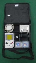 A Nintendo Game Boy Hand Held Games Console, Tetris and On The Tiles Games Cartridges, Magnifier