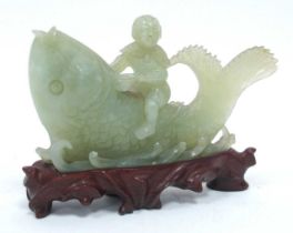 A XX Century Chinese Jade Carving of a Boy Riding a Large Fish, hardwood stand, 16cm long. Stand -