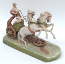 A Royal Dux Pottery Model of a Young Man Riding a Chariot Pulled by Two Rearing Horses, on a