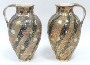A Pair of Hungarian Pottery Ewers, richly decorated with swirling bands of flowers on alternating