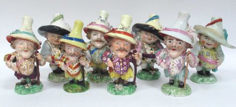 Eight Mid XIX Century Derby and Other Pottery Mansion House Dwarfs, each wearing a hat and colourful