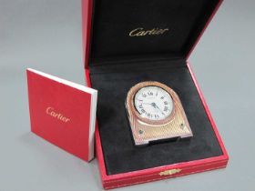 A Cartier Stainless Steel Desk Clock, with arched top, the circular dial with Roman numerals, engine