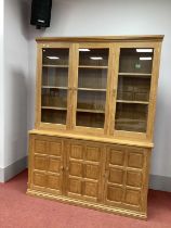 A Beaverman Oak Bookcase, with three glazed upper doors and three panelled doors to base, panelled