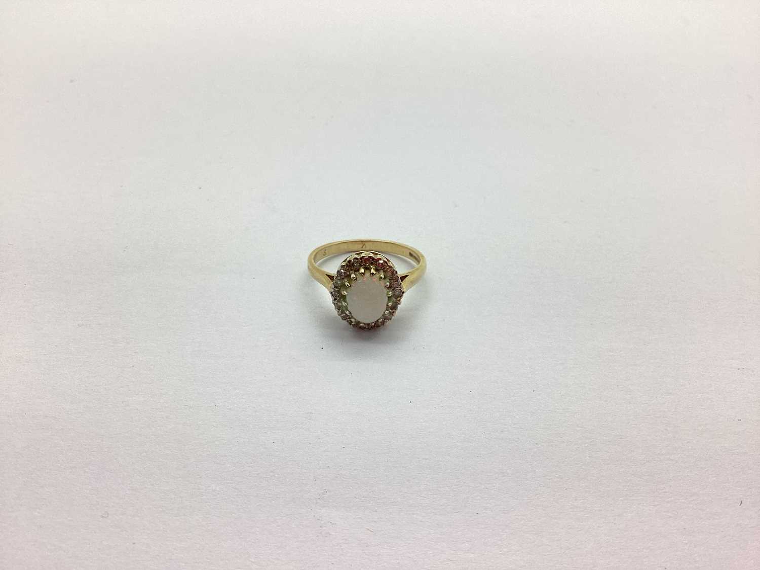 A 9ct Gold Cluster Ring, oval claw set centre, within claw set border, between tapered shoulders (