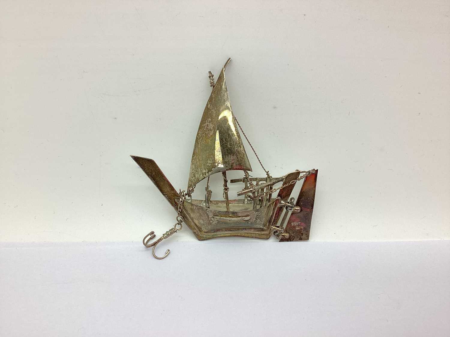 A Novelty Model of a Ship at Sail, with articulated rudder and anchor, 8.5cm high, stamped "silver