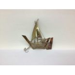 A Novelty Model of a Ship at Sail, with articulated rudder and anchor, 8.5cm high, stamped "silver