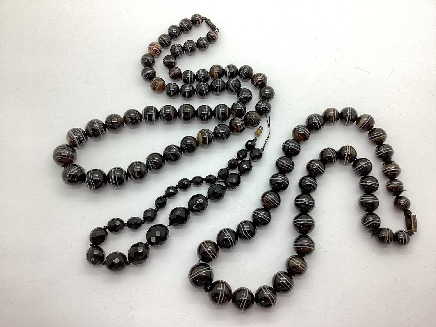 Two Victorian Banded Agate Single Strand Bead Necklaces, together with French jet graduated bead