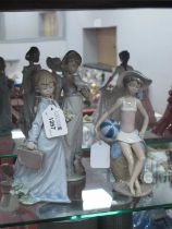 Three Lladro Figurines, of girls carrying flowers, holding a bird, in beach wear.