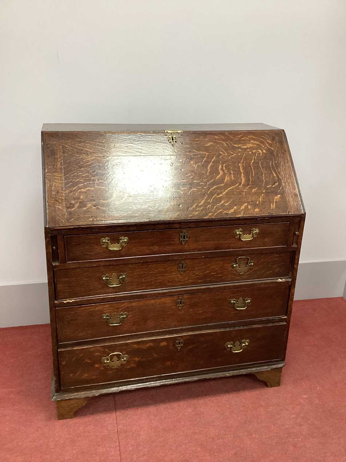 An XVIII Century Oak Bureau, with fall front and fitted interior above four long drawers, on bracket