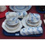 A Stafford Bone china Tea Service, decorated with forget-me-nots with floral molded handles:- One