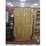 A Pine Twi Door Wardrobe, with single internal shelf and rail, raised on bun feet, 180cm high.