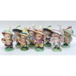 Eight Mid XIX Century Derby and Other Pottery Mansion House Dwarfs, each wearing a hat and colourful