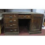 Late XIX Century Oak Pedestal Desk, with a crossbanded top, flanking pedestals, with a cupboard