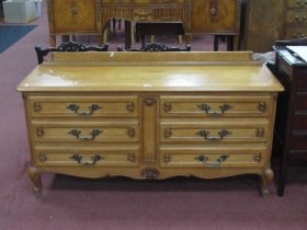 A French Style Oak Chest of Drawers, with moulded edge over six small drawers on scroll feet,