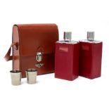 An Art Deco Bentley hide motoring drinks case containing two glass decanters with two plated