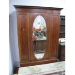 An Edwardian mahogany inlaid wardrobe with single mirrored door over long drawer, on a plinth