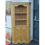 A Pine Floor Standing Corner Cupboard, the top with two open shelves, the base with doors