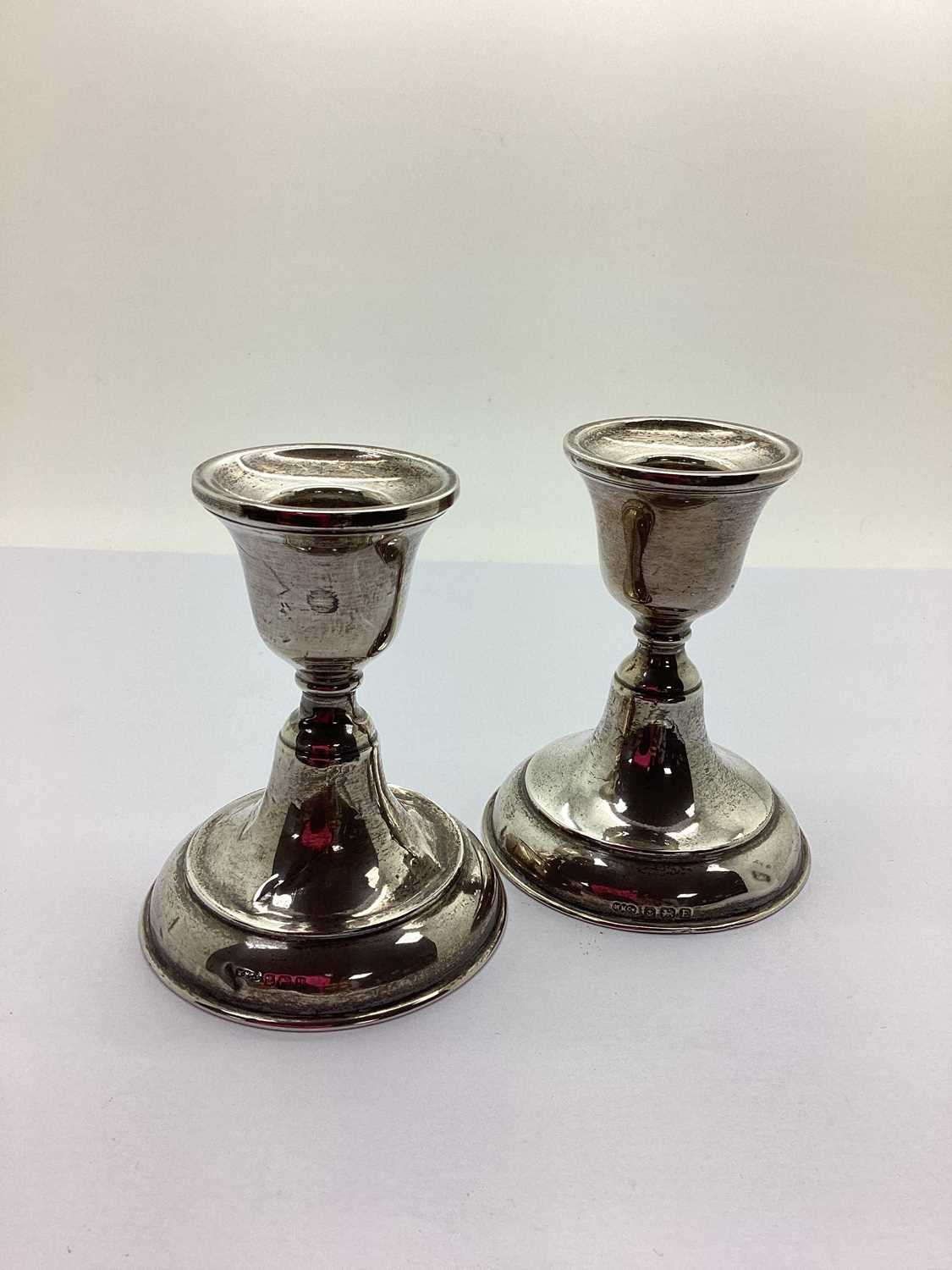 A Matched Pair of Hallmarked Silver Candlesticks, (bases weighted) 9cm high (dents). (2)