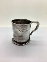 A Hallmarked Silver Christening Mug, engraved 'Theodore' (75grams) (dented / misshapen).