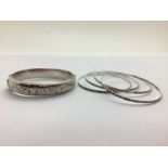 A Hallmarked Silver Hinged Bangle, leaf scroll engraved to the front; together with a set of four