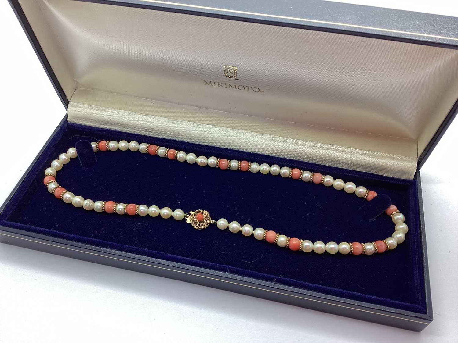A Pearl and Coral Bead Necklace, of alternate design, to 9ct gold textured clasp, in a Mikimoto