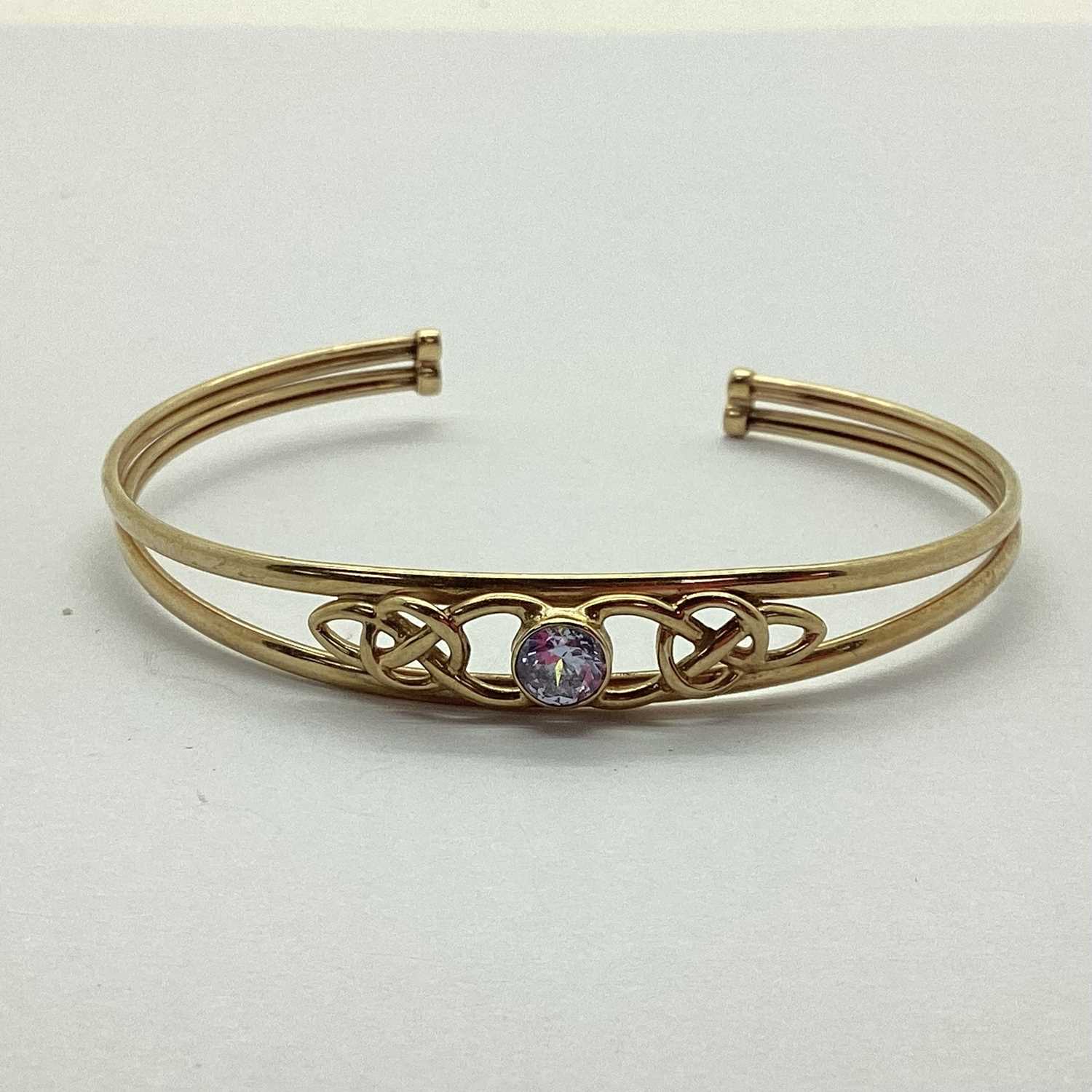 A Hallmarked 9ct Stone Set Bifuricated Bangle, the collet set stone, between Celtic knot style