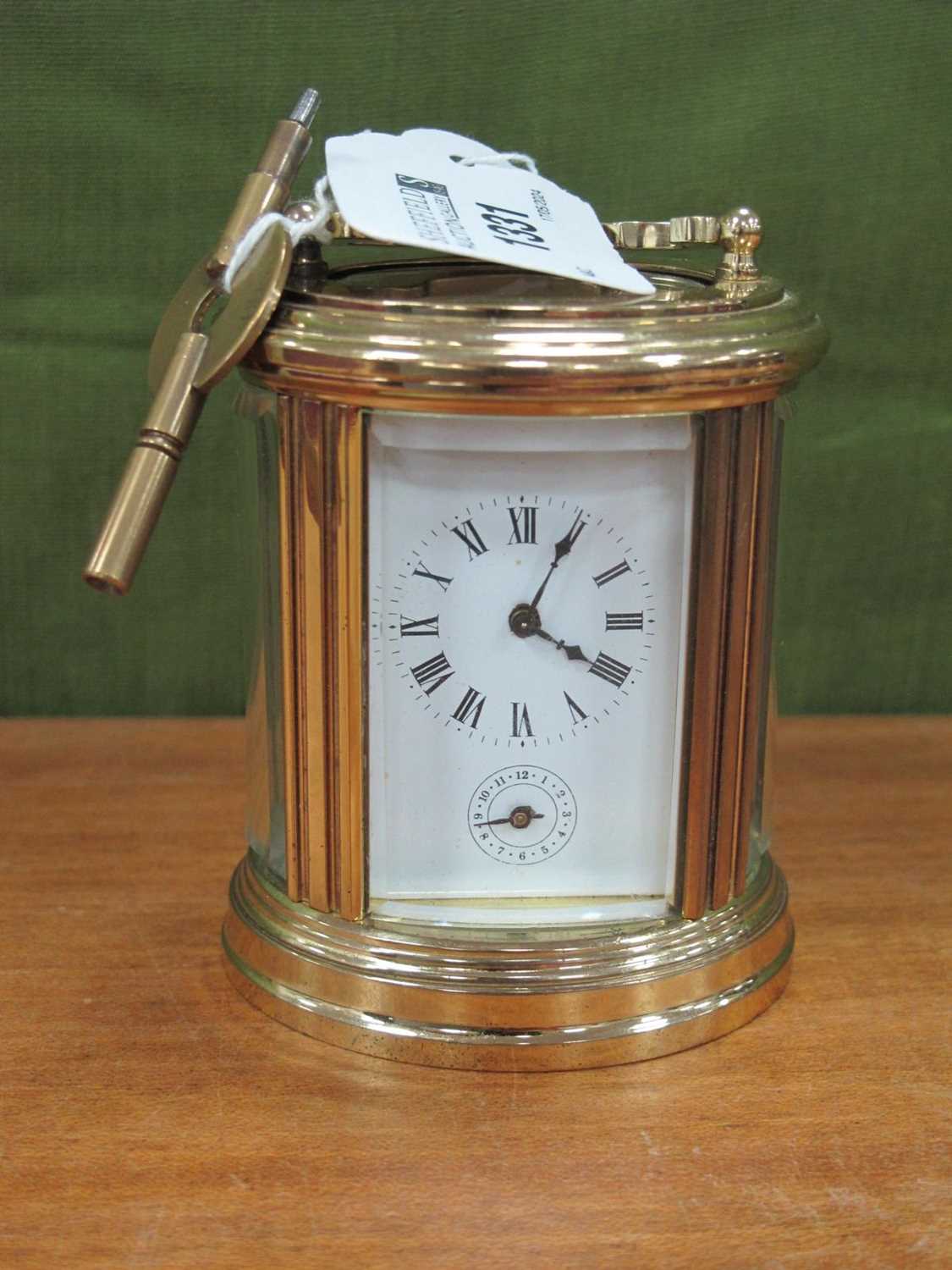 L'epee, Miniature brass oval carriage mantel clock timepiece, 8cm high with handle down, together