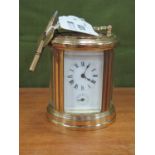 L'epee, Miniature brass oval carriage mantel clock timepiece, 8cm high with handle down, together