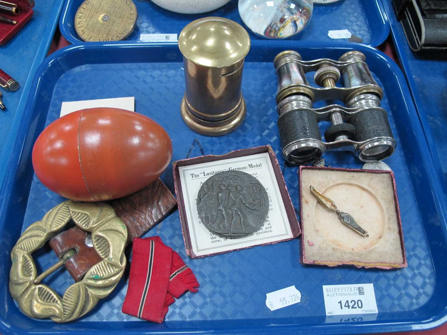 Lustiania Medal, brass money box, two pairs of opera glasses, buckle, mini mummy, etc:- One Tray.