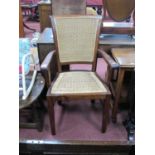 A Hardwood Open Elbow Chair, with caned back and seat, on square supports.