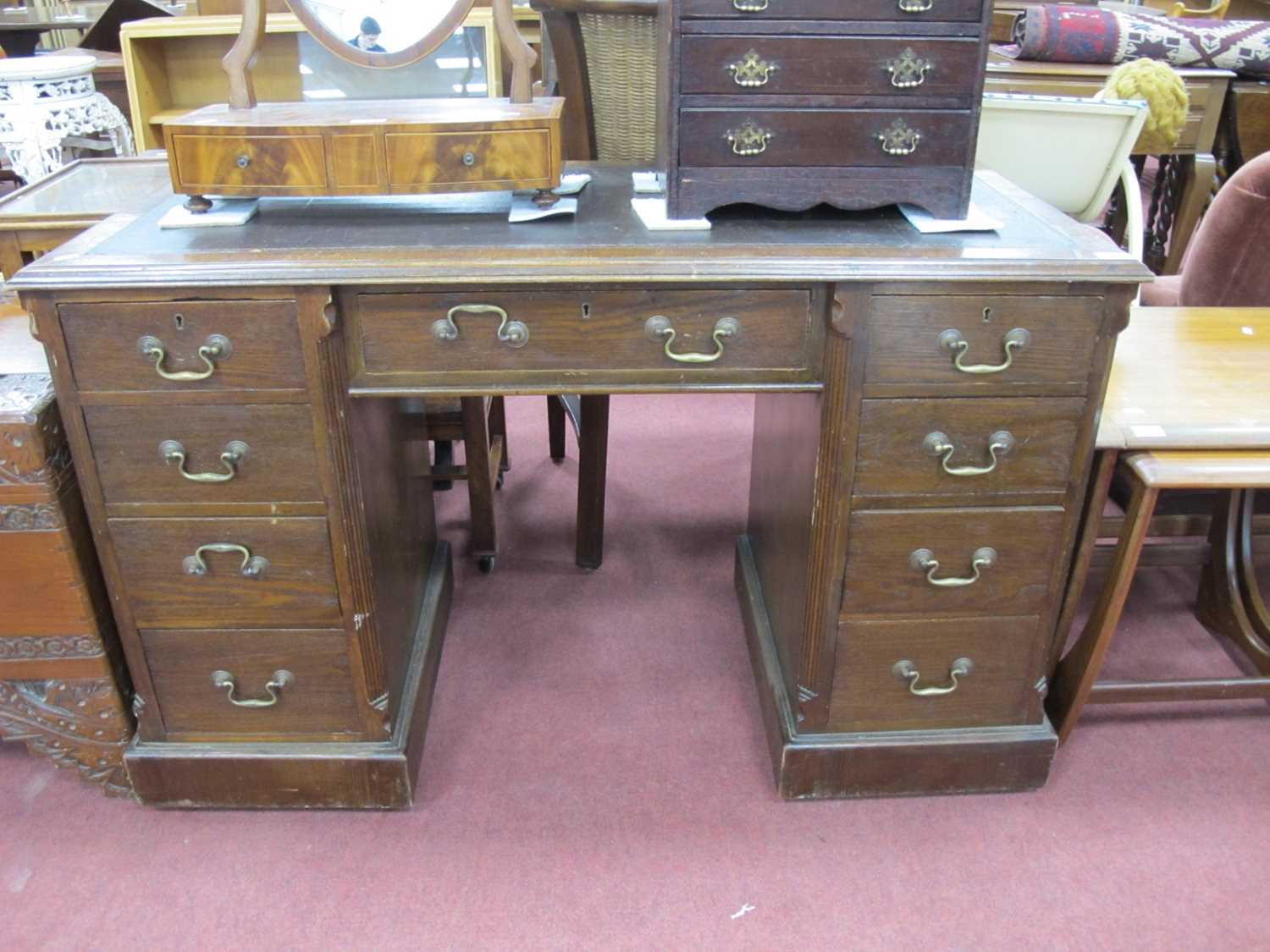 An Early XX Century Oak Pedestal Desk, with crossbanded top, brown leather insert over central