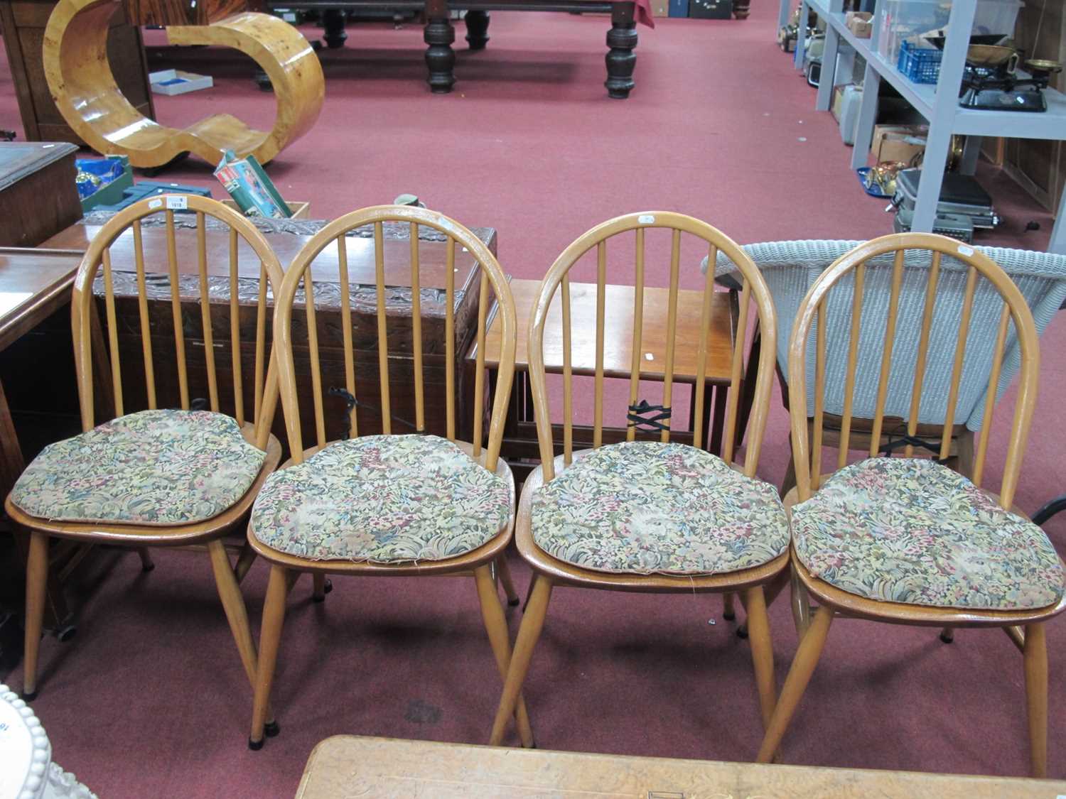 Ercol, Set of Four Light Wood Low Hoop top chairs, with spindle backs on splayed legs.