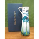 A Moorcroft Pottery Jug Vase, painted with a stylised blue poppy design on a cream ground, impressed