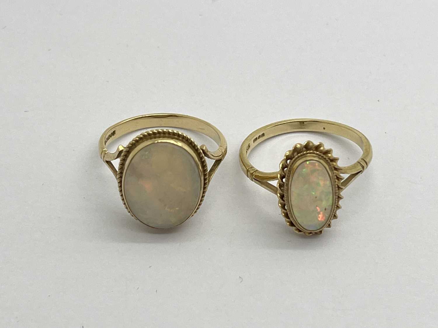 Two 9ct Gold Vintage Opal Set Rings, the oval stones to rubover setting, within twisted border,