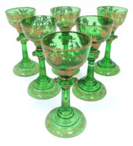 A Set of Six Early XX Century Bohemian Green Glass Goblets, the bowls with gilt forest scenes with